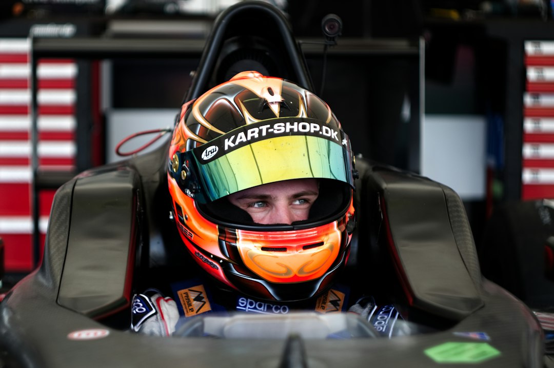 Piloto de carreras dentro del cockpit con casco, como ejemplo de las demandas físicas del automovilismo